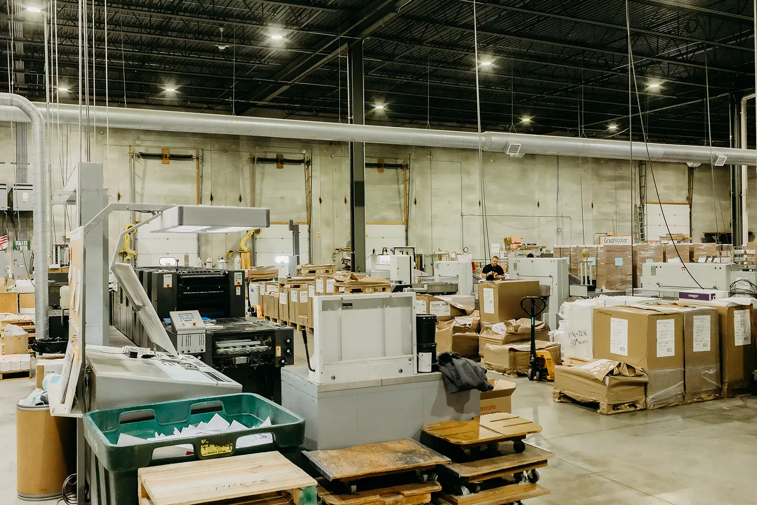 Offset printing press and paper stacks on shop floor in the Milwaukee Area Offset printing press and paper stacks on shop floor in the Milwaukee Area